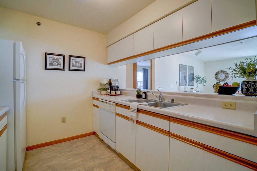 a kitchen with white cabinets and a sink and a refrigerator