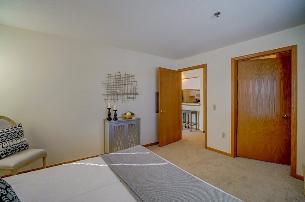 a bedroom with a bed and a door to a bathroom