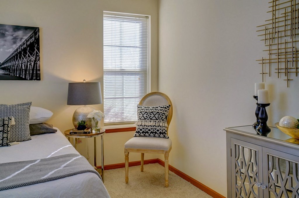 a bedroom with a bed and a chair and a dresser