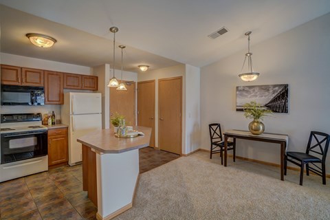 a kitchen and dining room with a table and chairs and a refrigerator