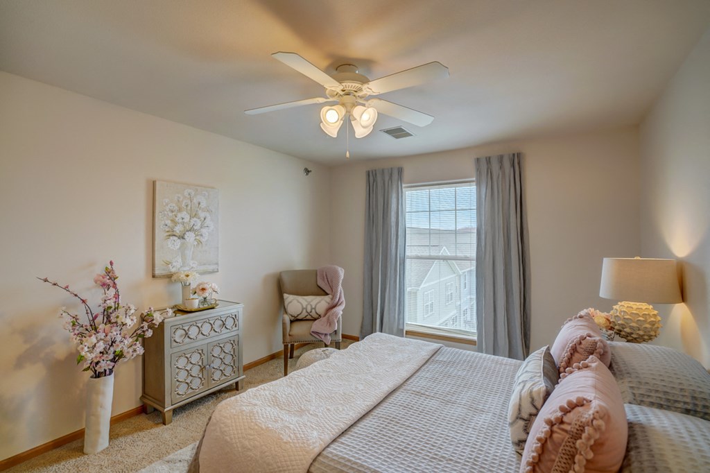 a bedroom with a large bed and a ceiling fan