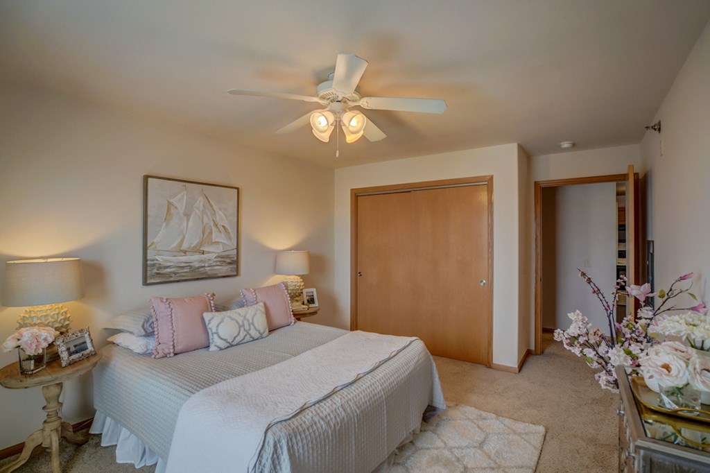 a bedroom with a large bed and a ceiling fan