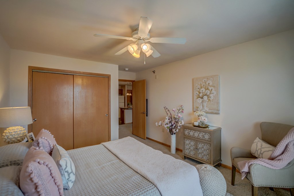 a bedroom with a bed and a ceiling fan