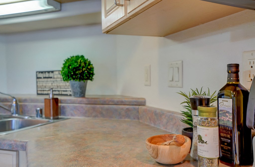 a kitchen counter with a bowl and bottles of wine on it