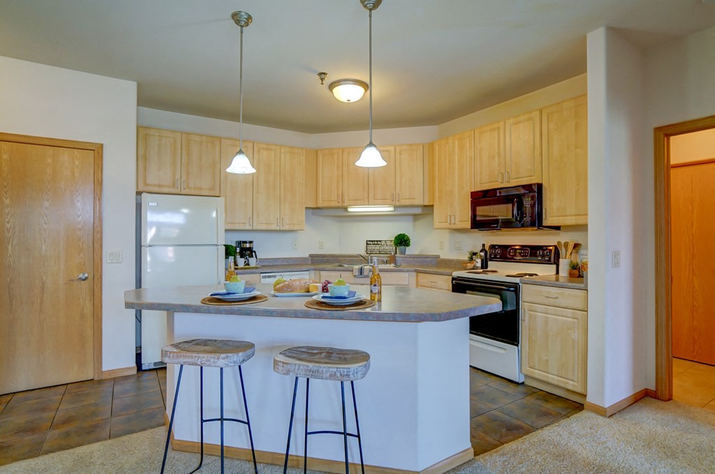 a kitchen with a center island and two stools