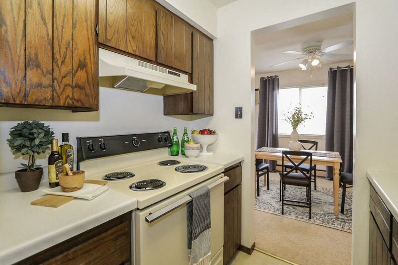 a kitchen with a stove and a dining room with a table