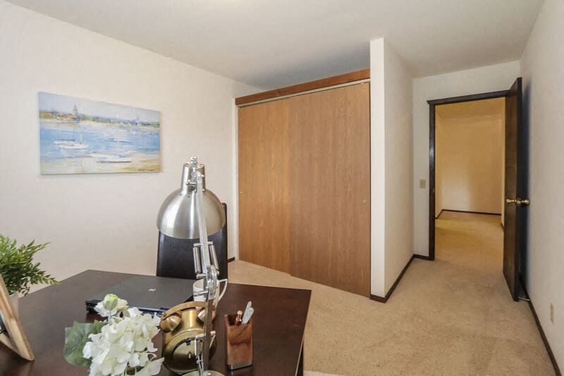 a living room with a table and a hallway with a door