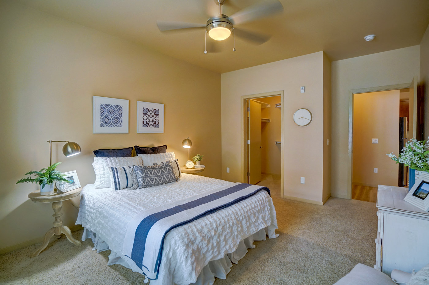 a bedroom with a large bed and a ceiling fan