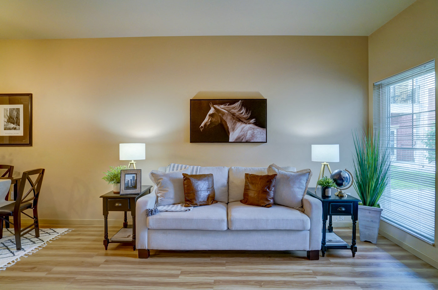 a living room with a couch and a painting of a horse