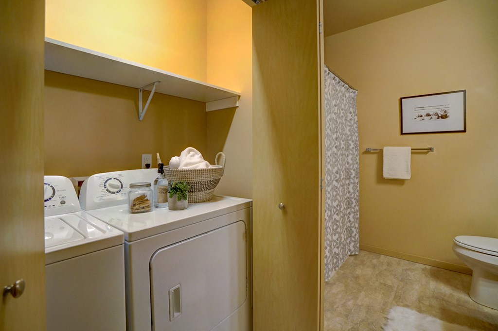 a bathroom with a washer and dryer and a shower and a laundry room