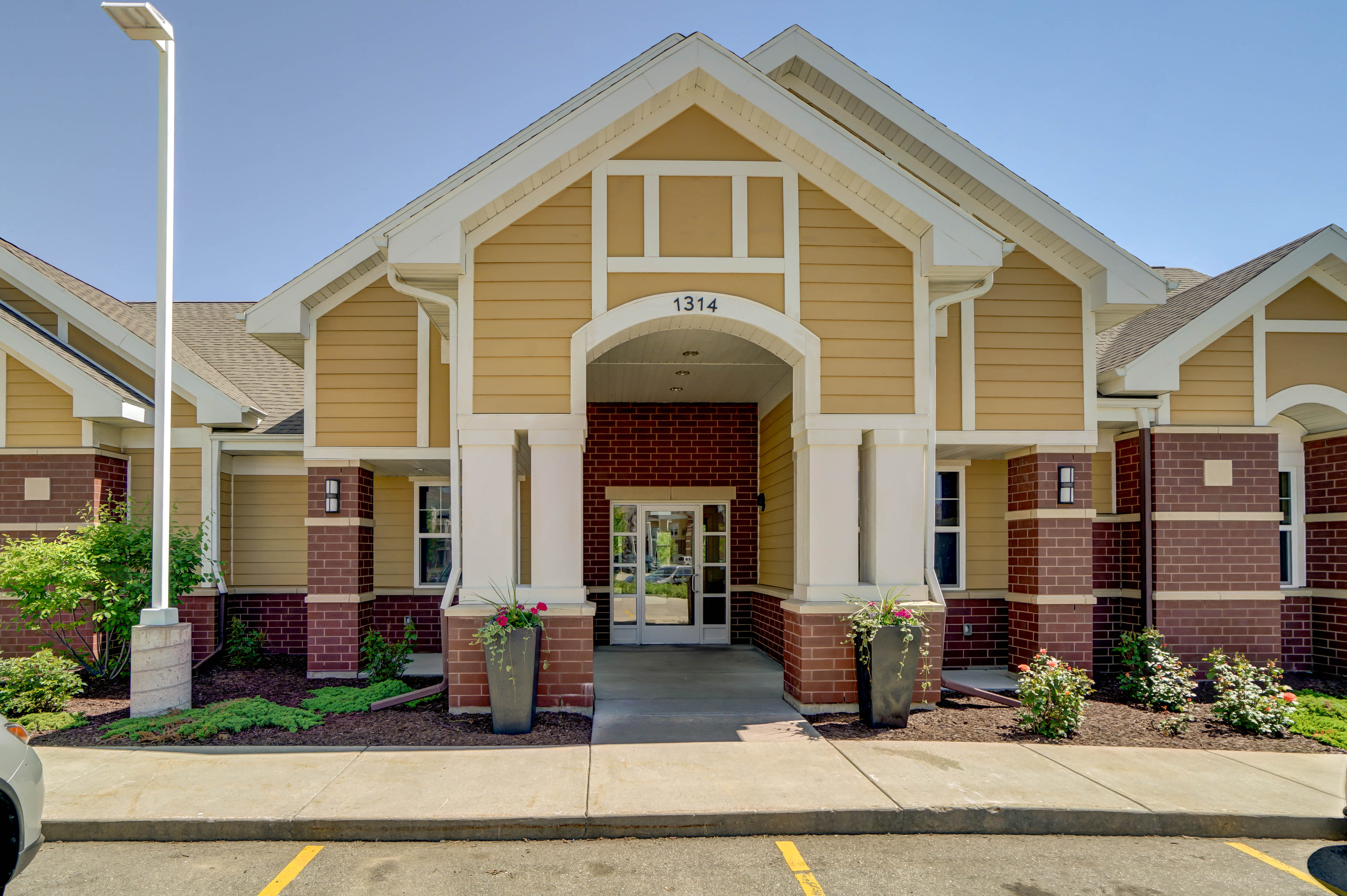 the front of a building with a porch and a walkway