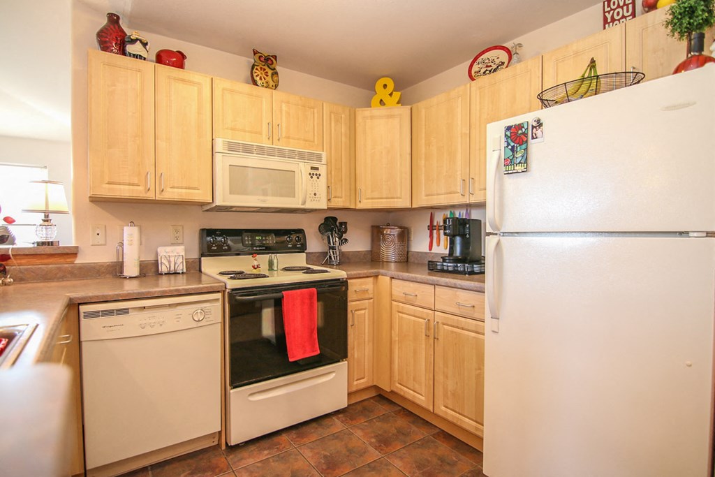 a kitchen with white appliances and wooden cabinets