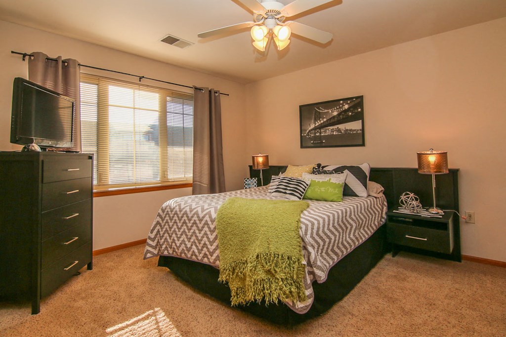 a bedroom with a bed and a ceiling fan