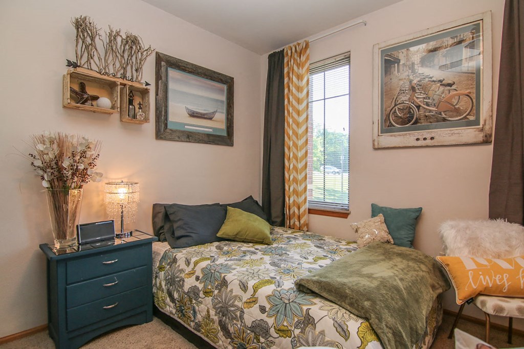 a bedroom with a bed and pictures on the wall