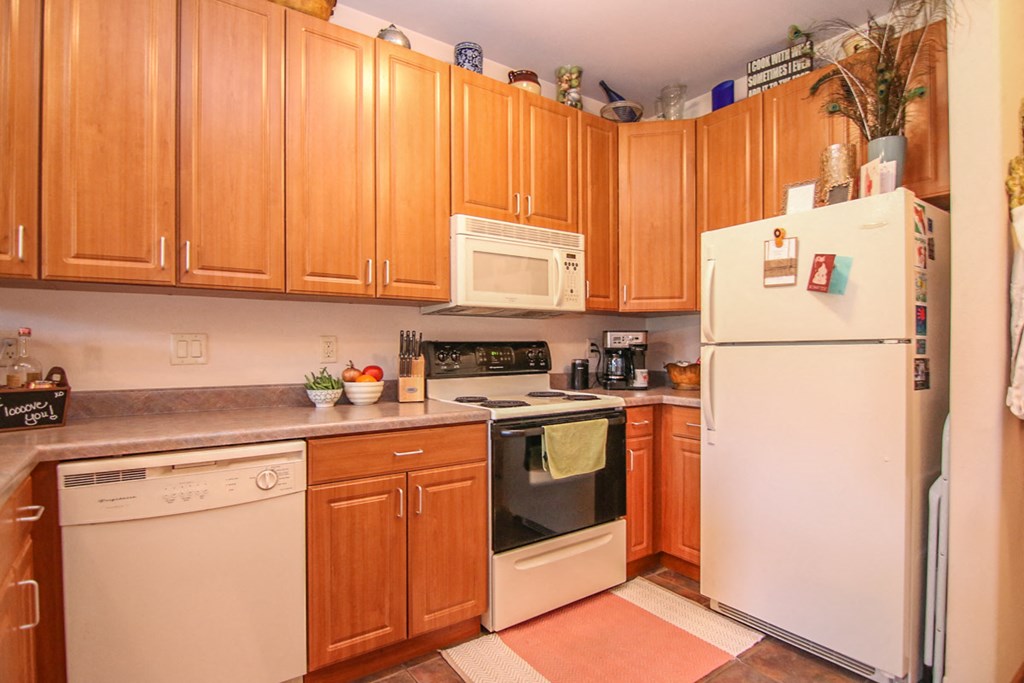 a kitchen with white appliances and wooden cabinets