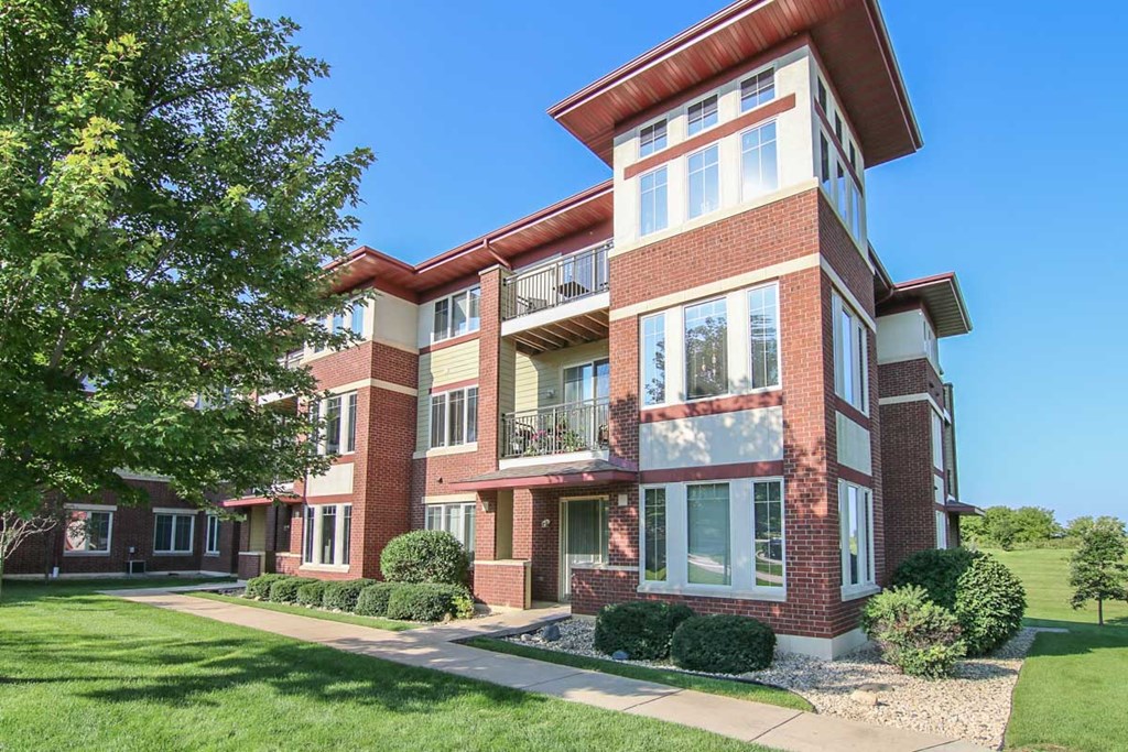 a red brick apartment building with a sidewalk in front of it