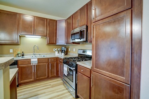 a kitchen with wooden cabinets and stainless steel appliances