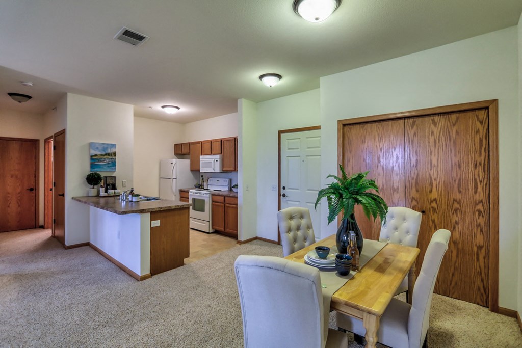a dining room and kitchen with a table and chairs