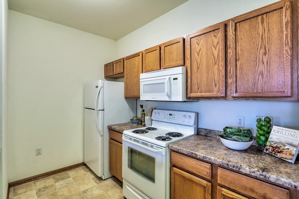 a kitchen with white appliances and wooden cabinets