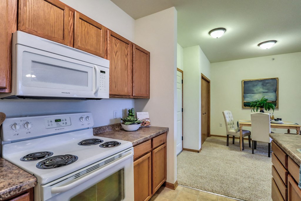 a kitchen with white appliances and a microwave above the stove