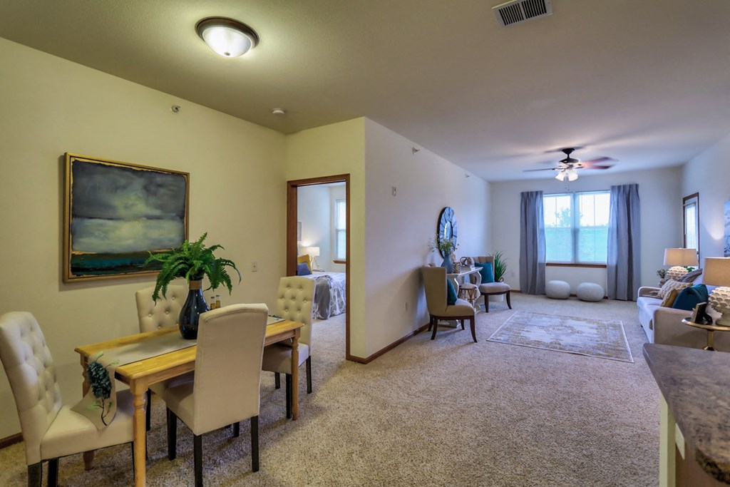 a living room and dining room with a table and chairs