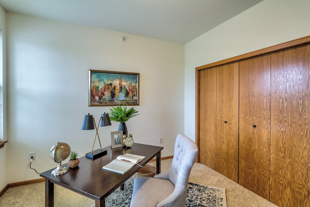 a home office with a desk and chair and a closet