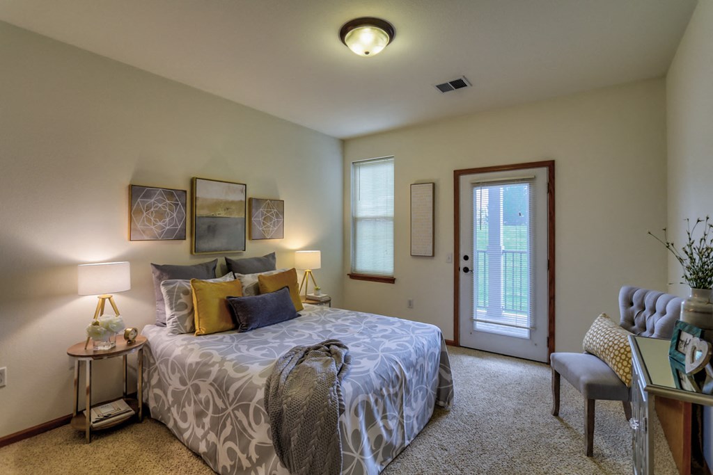 a bedroom with a bed and a door to a balcony