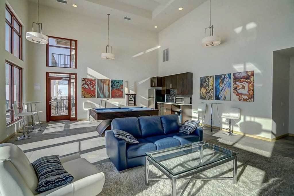 a living room with a blue couch and a pool table
