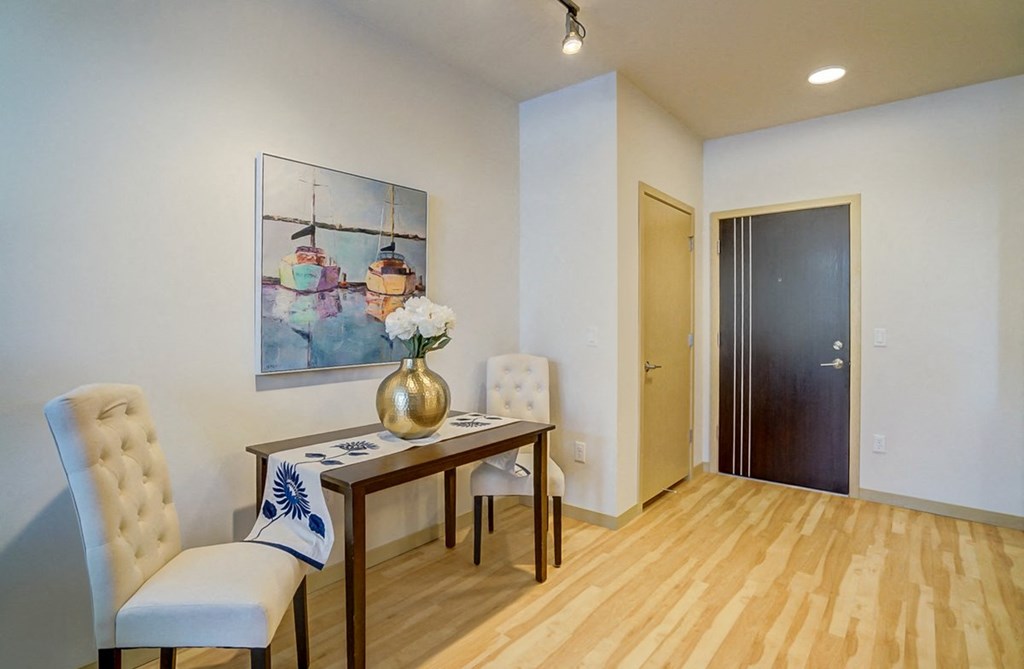 a dining room with a table and chairs and a painting on the wall