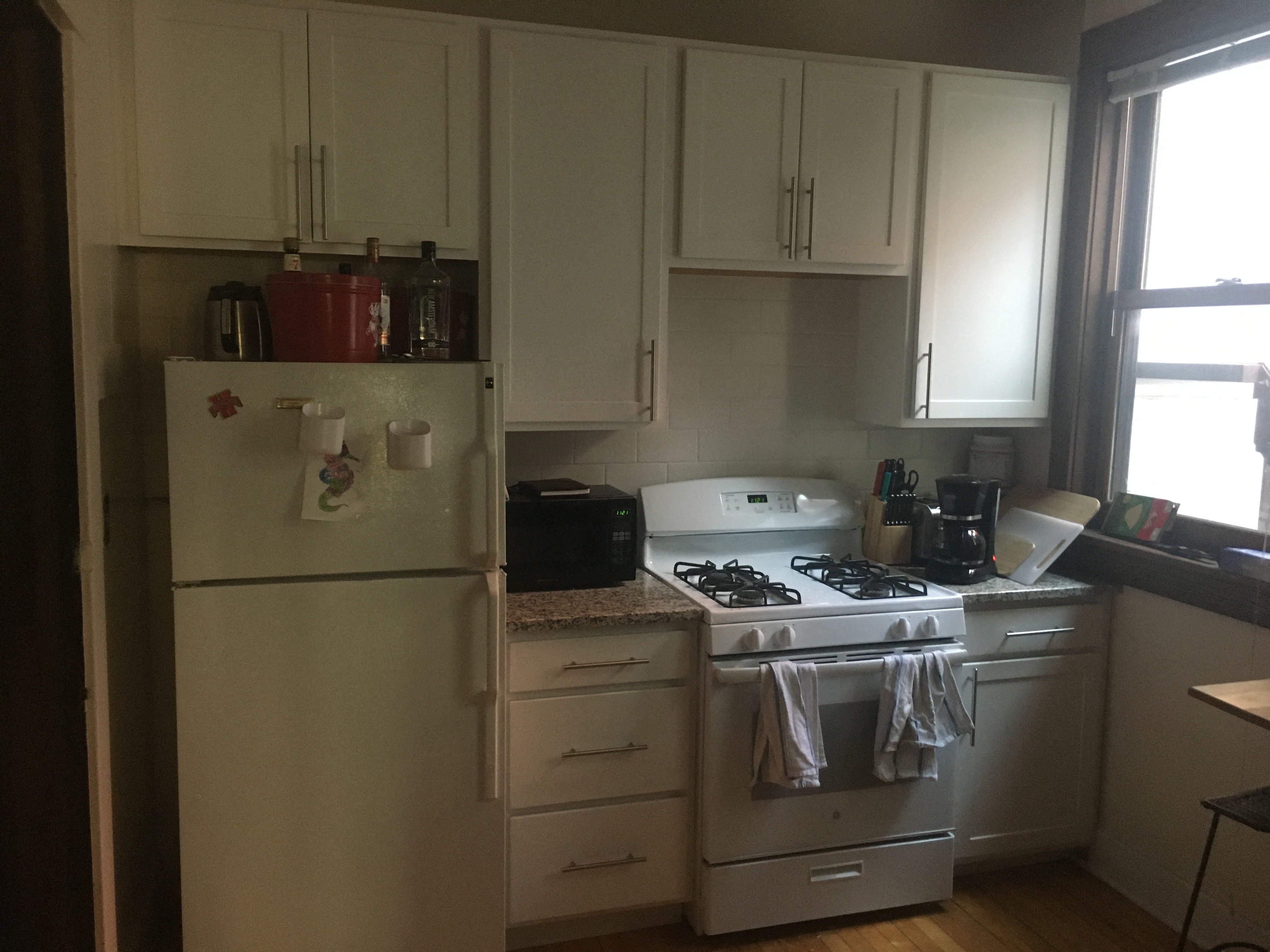 a kitchen with white appliances and white cabinets