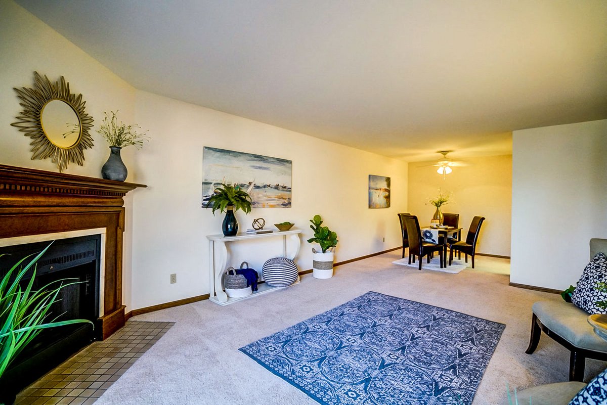 a living room with a fireplace and a dining room table