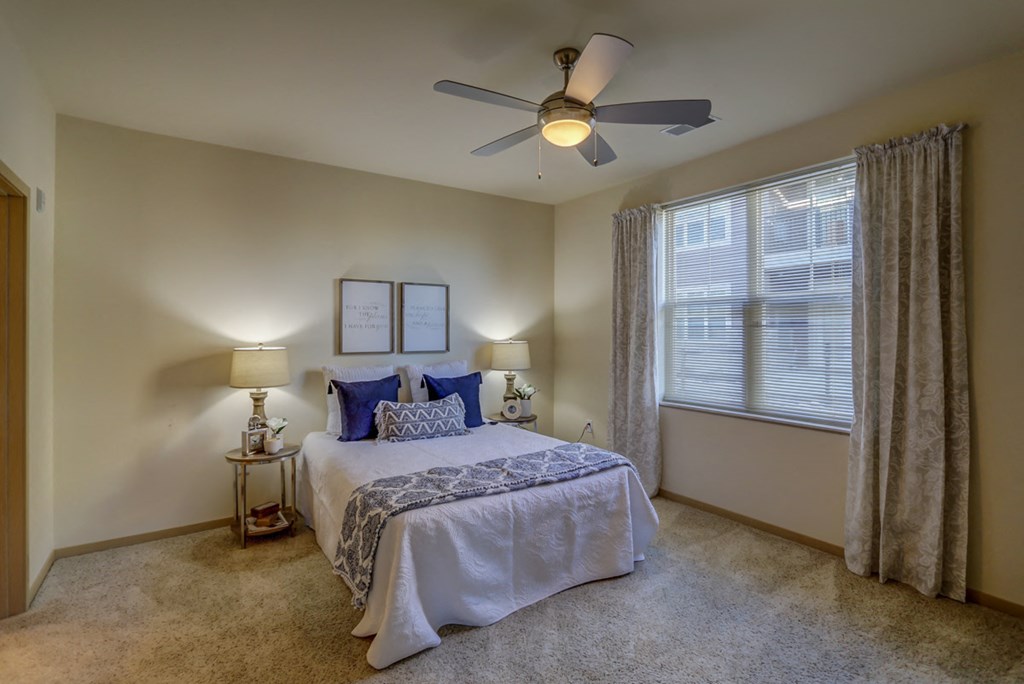 a bedroom with a bed and a ceiling fan