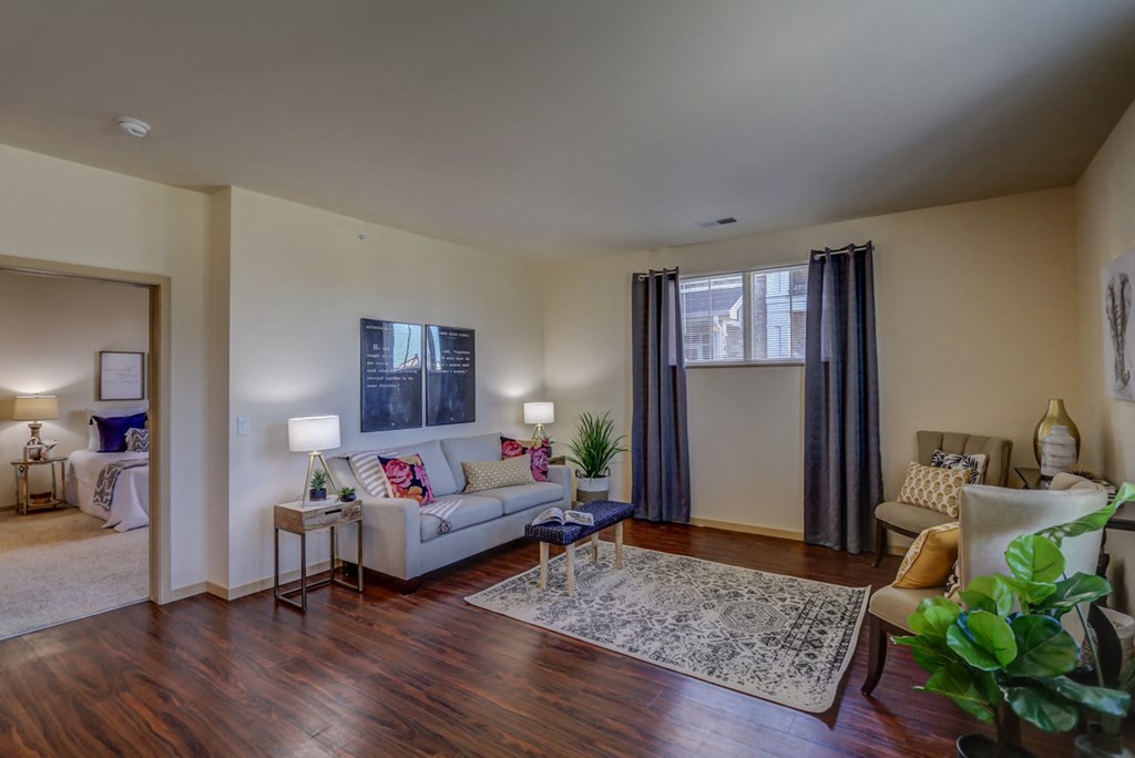 a living room with a couch and a chair and a window