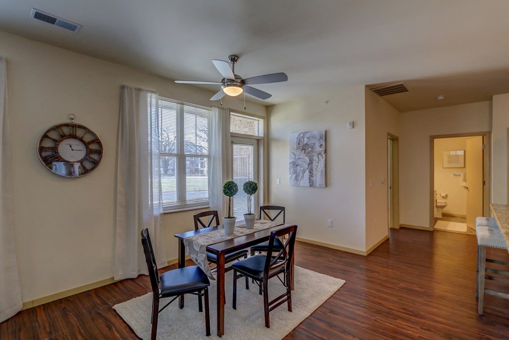 a dining room with a table and chairs and a ceiling fan