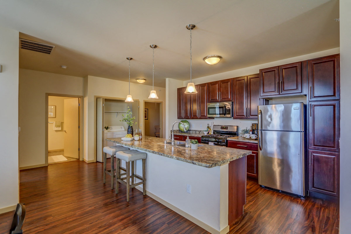 a kitchen with stainless steel appliances and a marble counter top