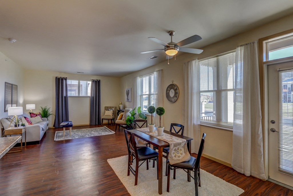 a living room with a dining room table and a ceiling fan