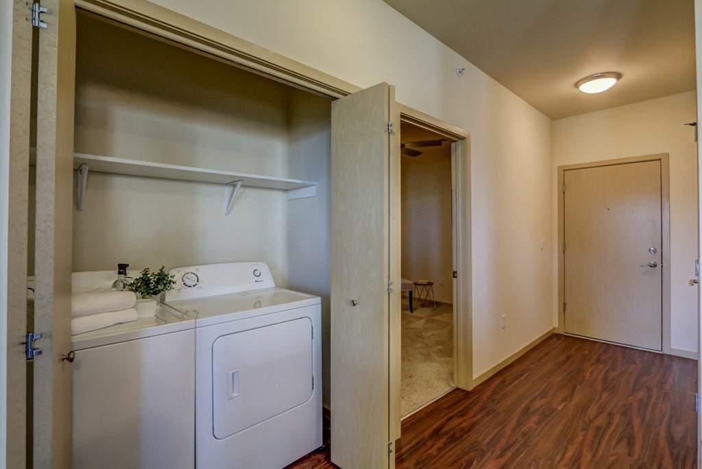 a laundry room with a washer and dryer and a door to a bathroom