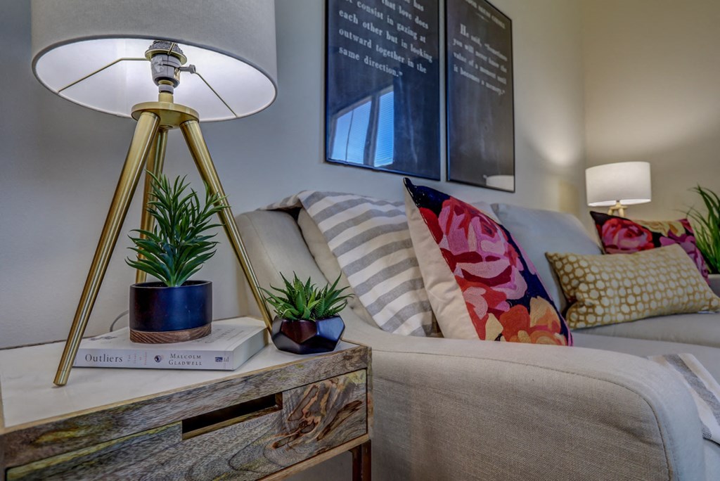 a living room with a couch and a table with a lamp