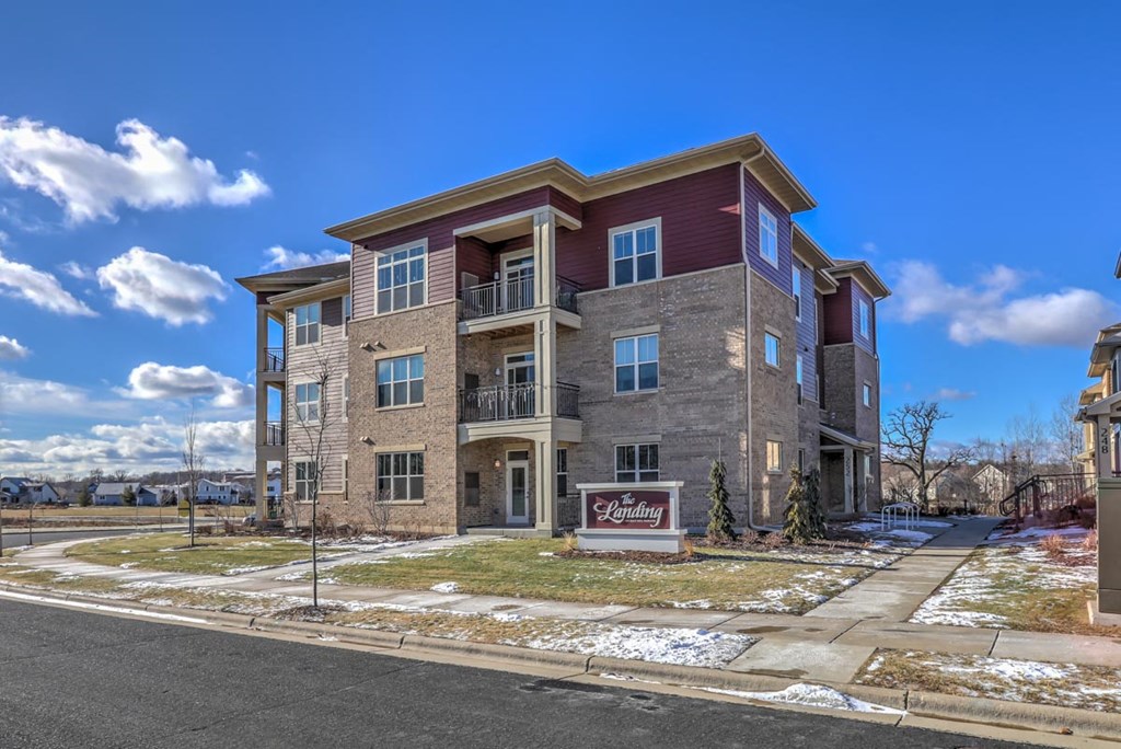 a building with a sign in front of it on a sidewalk