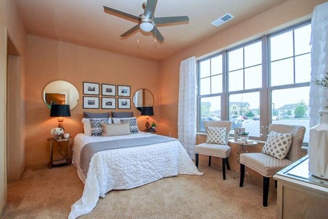 a bedroom with a large bed and a ceiling fan