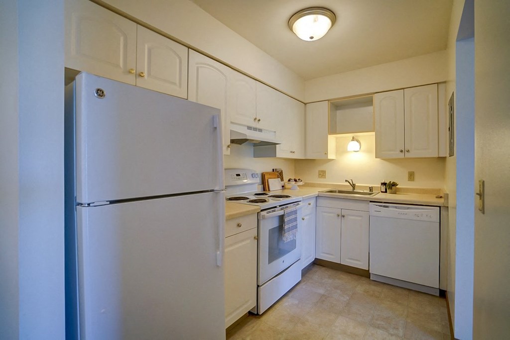 a kitchen with white appliances and white cabinets
