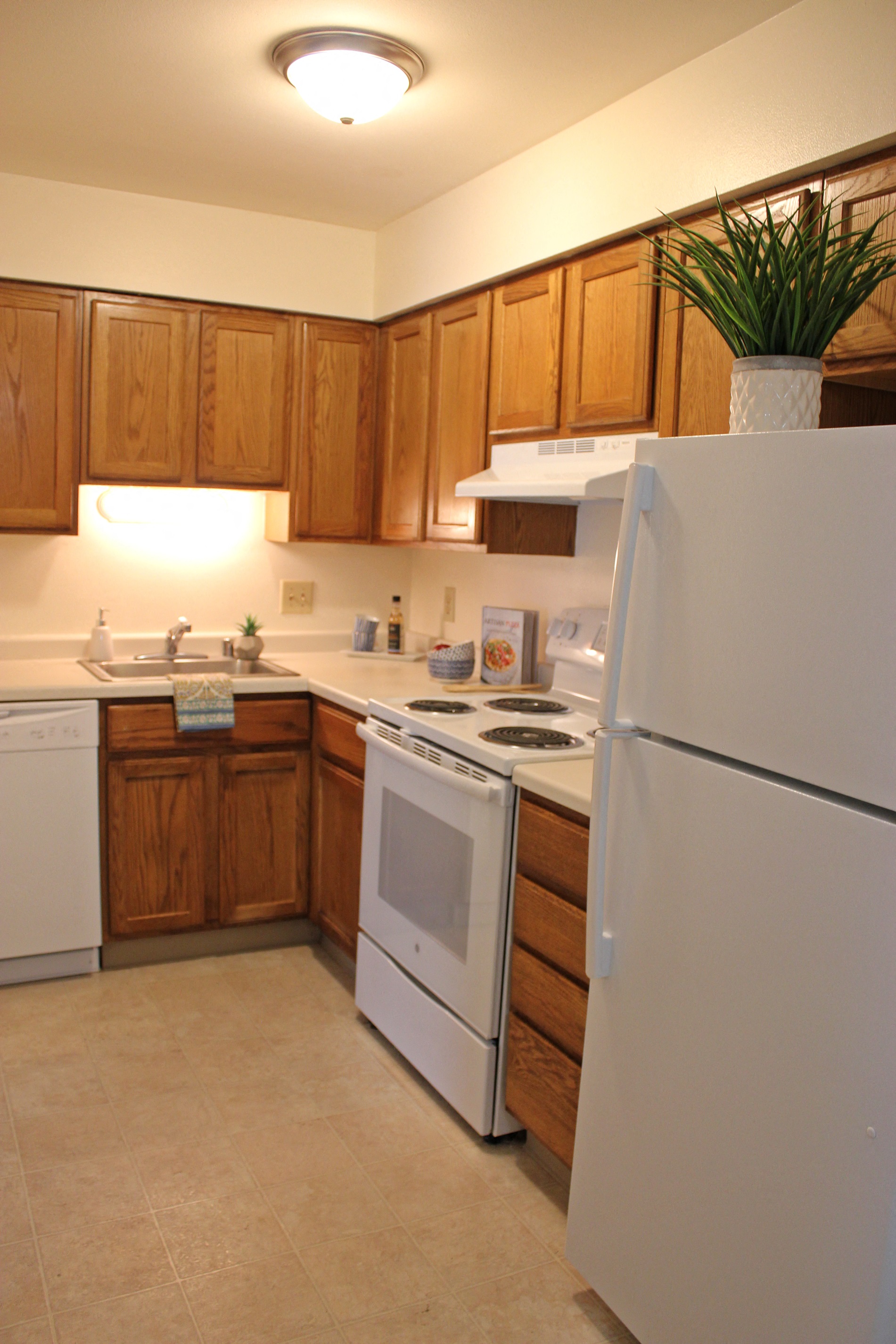 a kitchen with white appliances and wooden cabinets
