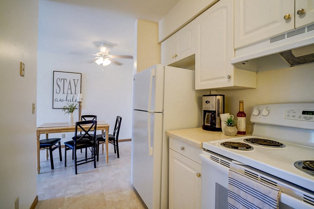 a kitchen with a stove and refrigerator and a dining table