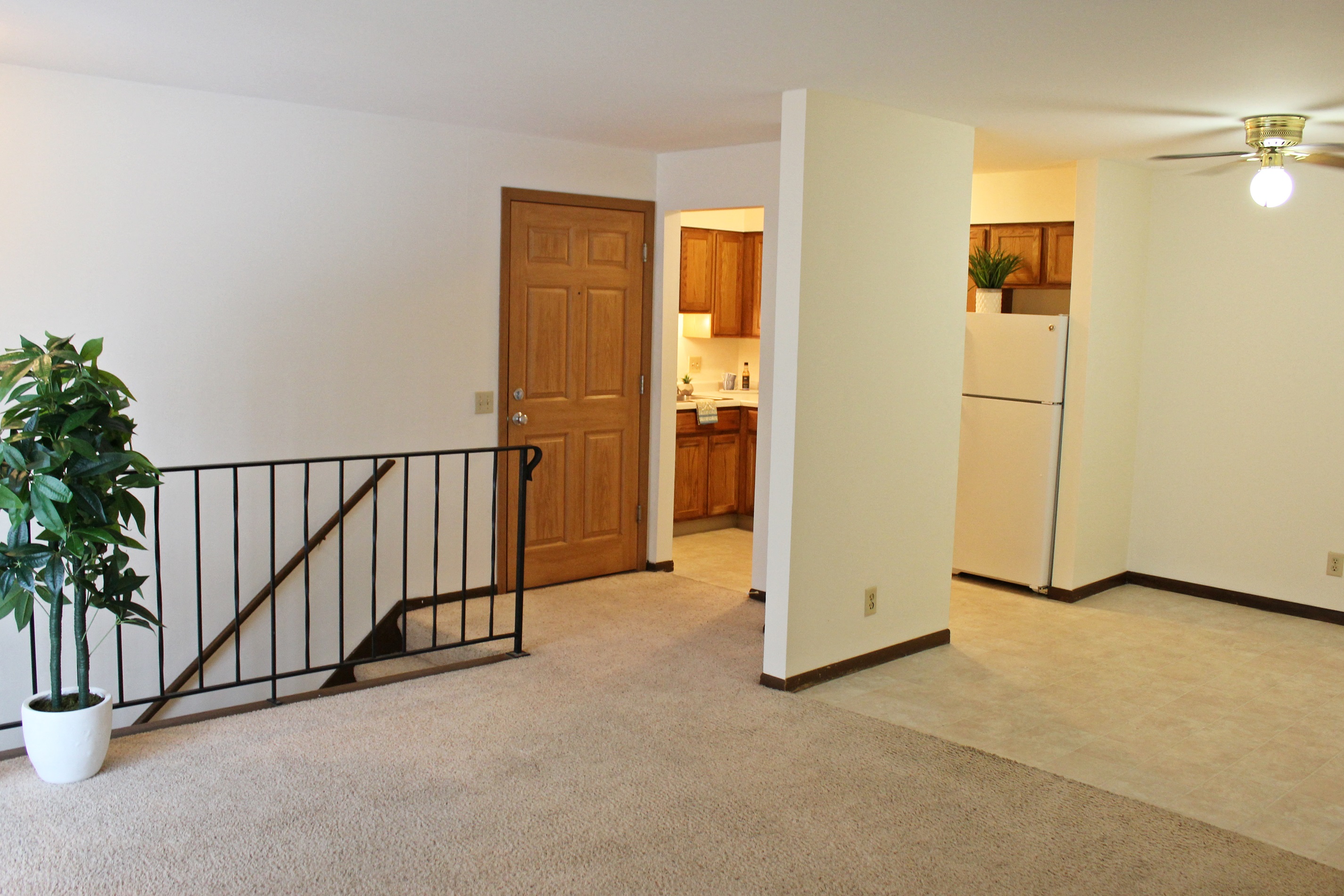 the view of a living room and kitchen from the top of a staircase
