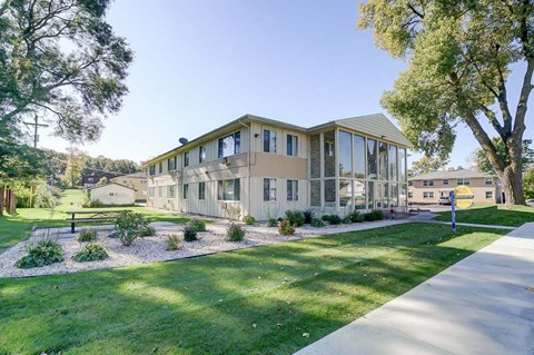 a building with a lawn and trees in front of it