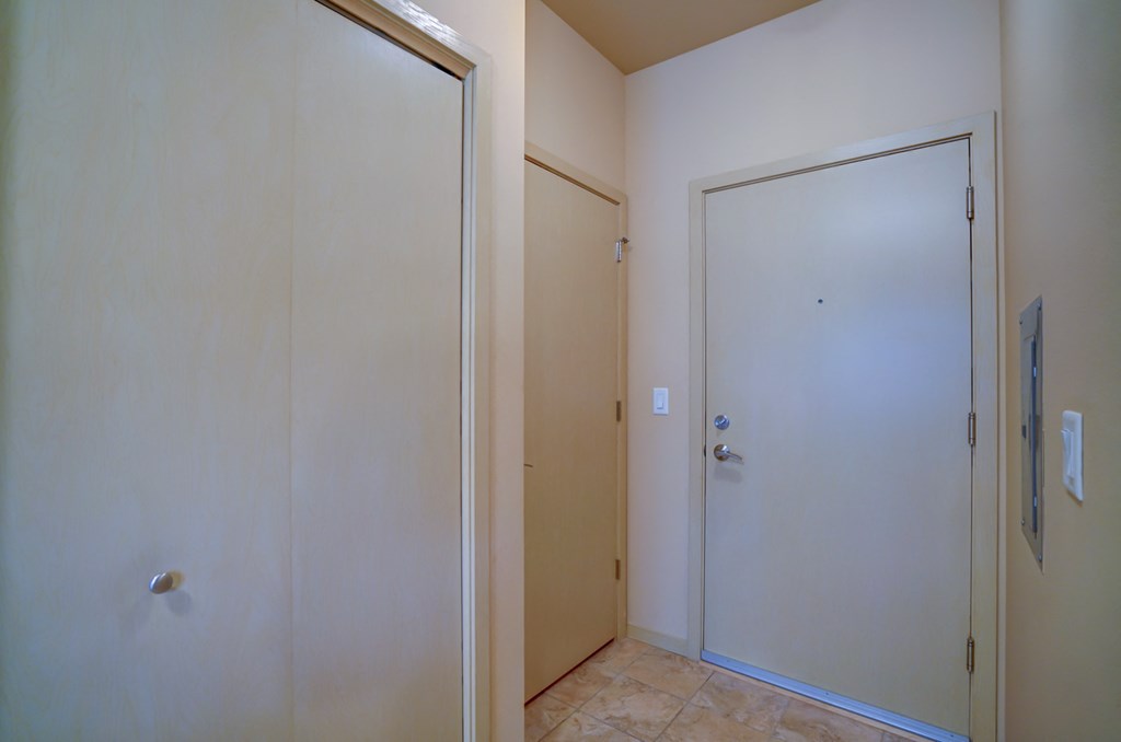 an empty room with a door to a closet and a tile floor
