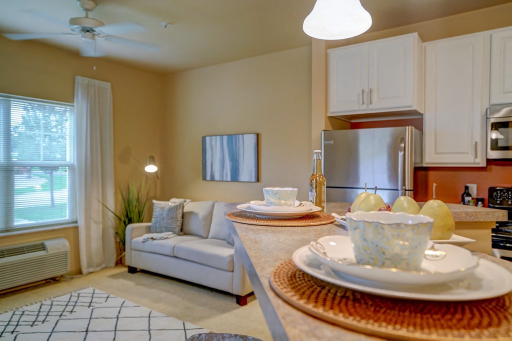 a kitchen and living room with a table with plates on it