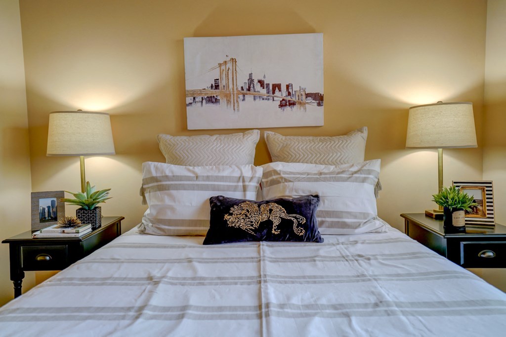 a bedroom with a bed and a painting on the wall