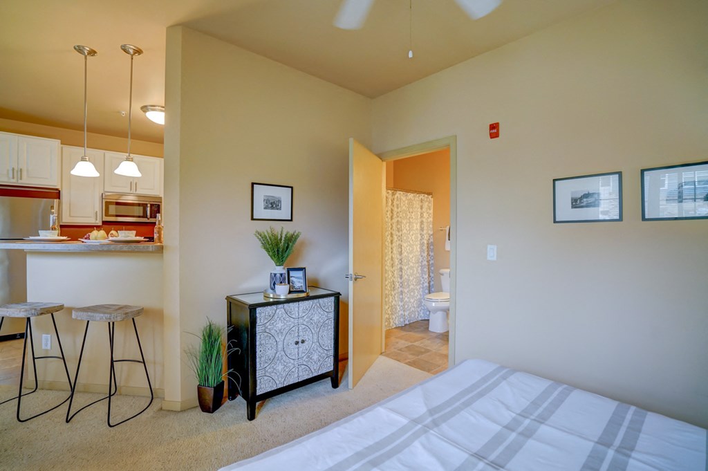 a bedroom with a bed and a bathroom with a sink and a toilet