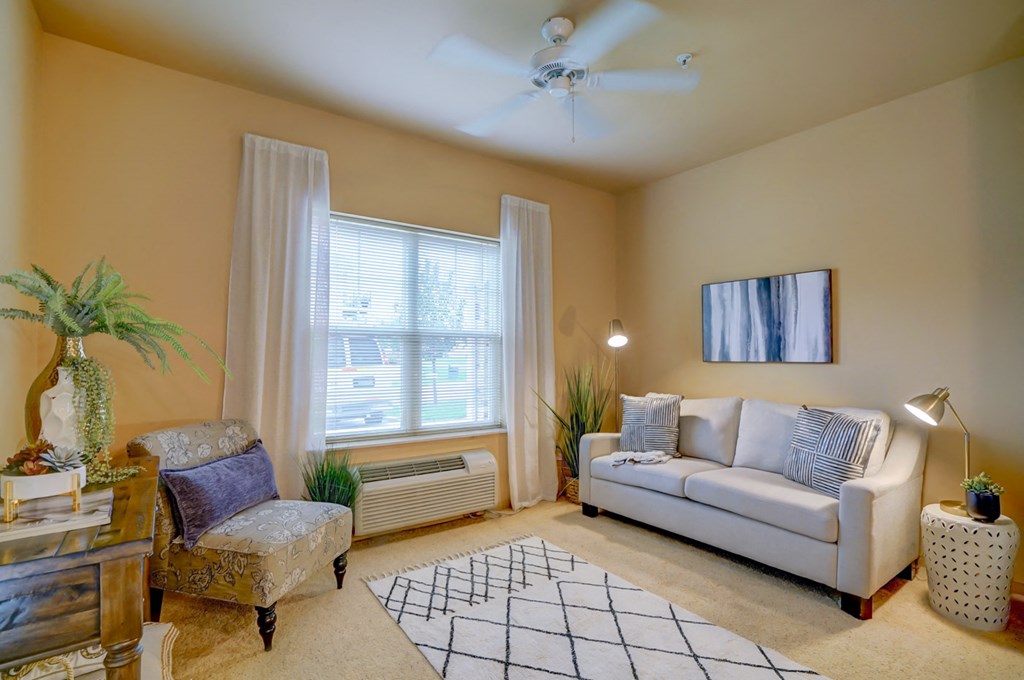 a living room with a white couch and a ceiling fan